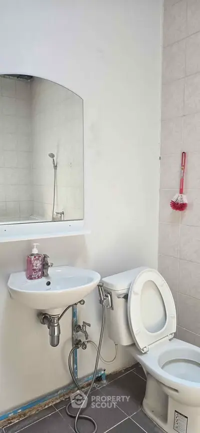 Compact bathroom with modern fixtures and wall-mounted mirror, ideal for efficient space utilization.