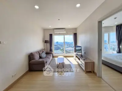 Modern living room with city view, cozy sofa, and natural light.