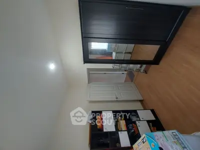 Spacious bedroom with wooden flooring and ample storage solutions