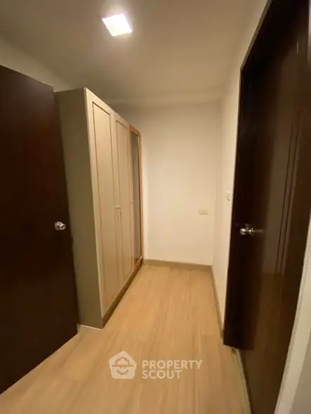 Compact storage area with wooden flooring and built-in wardrobe