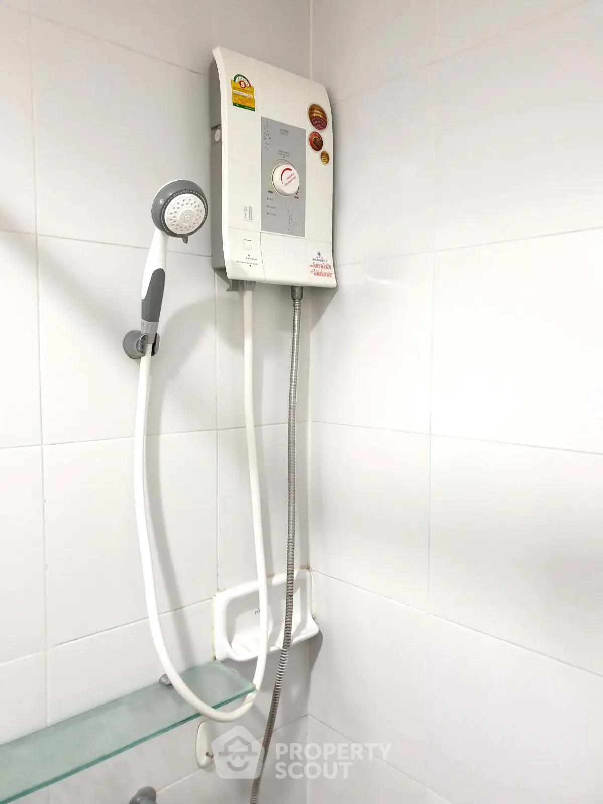 Modern bathroom with electric water heater and sleek white tiles.
