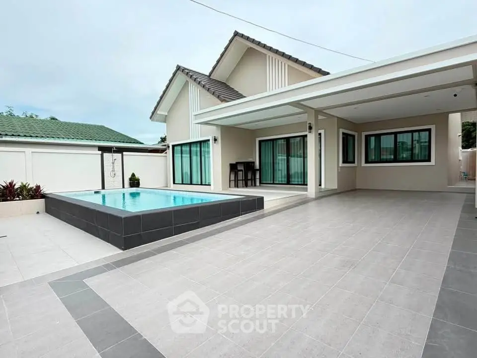 Modern home exterior with pool and spacious patio, perfect for outdoor living.