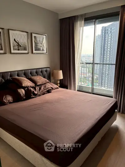 Cozy bedroom with city view and modern decor in high-rise apartment.