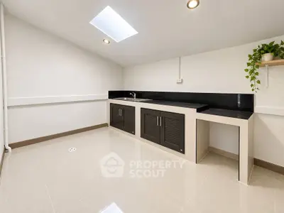 Spacious modern utility room with sleek cabinetry and skylight