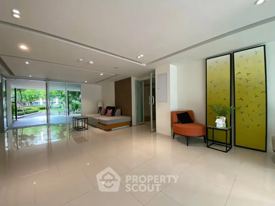 Spacious modern living room with elegant decor and large windows overlooking greenery.