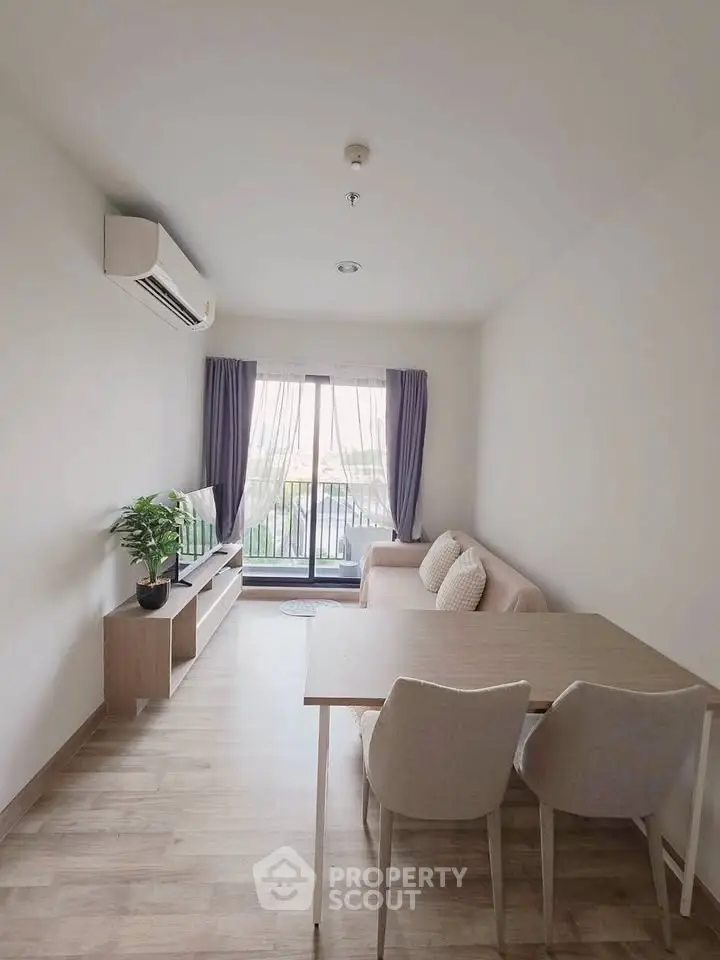 Modern living room with natural light, featuring a cozy sofa, dining table, and air conditioning.