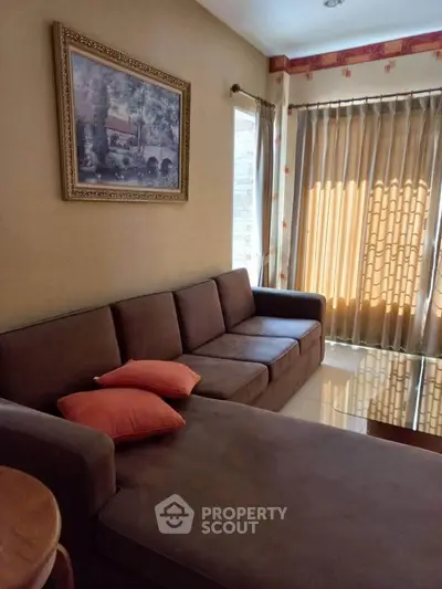 Cozy living room with brown sofa and elegant curtains, perfect for relaxation.