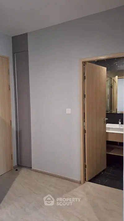 Modern bathroom entrance with sleek wooden door and minimalist design.