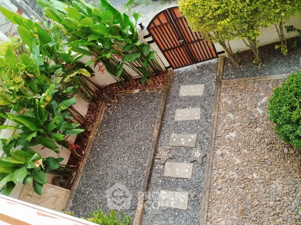 Charming garden with stone pathway and lush greenery, perfect for relaxation and outdoor enjoyment.