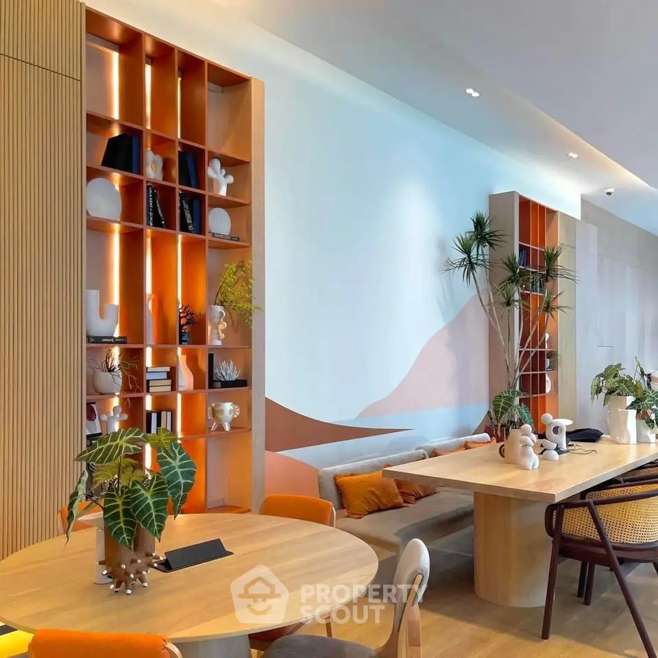 Modern living room with stylish decor and open shelving, featuring natural wood elements and vibrant plants.