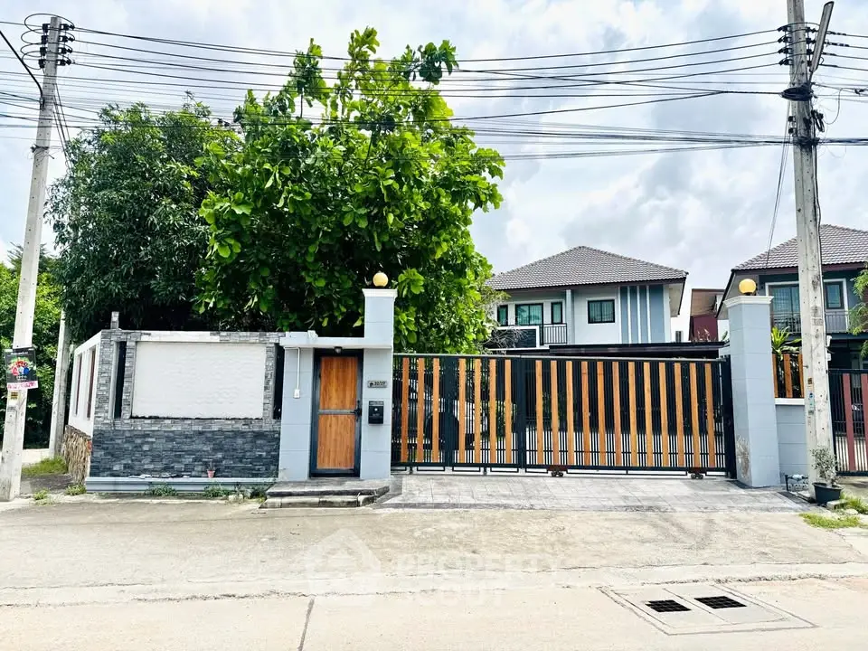 Modern gated house with lush greenery and stylish facade in suburban neighborhood.