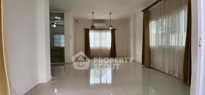 Spacious living room with large windows and elegant curtains