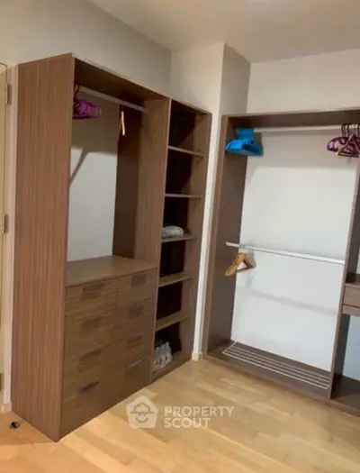 Spacious walk-in closet with wooden shelves and hanging space in modern home.
