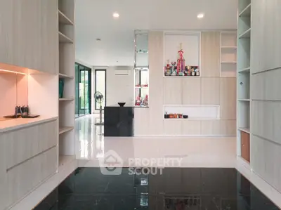 Spacious modern living room with sleek built-in shelves and glossy flooring, perfect for stylish urban living.