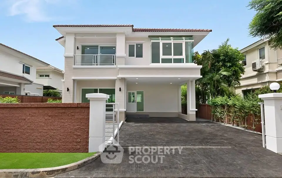 Modern two-story house with spacious driveway and lush greenery, perfect for family living.