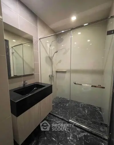 Modern bathroom with sleek glass shower and black marble flooring