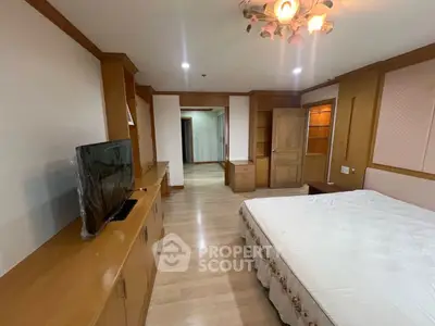 Spacious bedroom with wooden furniture and modern lighting
