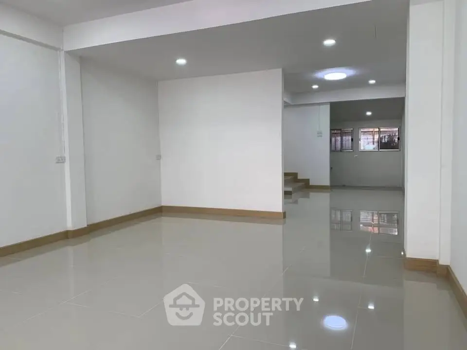 Spacious open-plan living area with modern tile flooring and ample natural light.