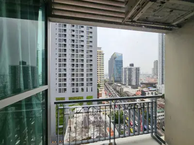 Stunning urban balcony view with modern skyscrapers and bustling cityscape.