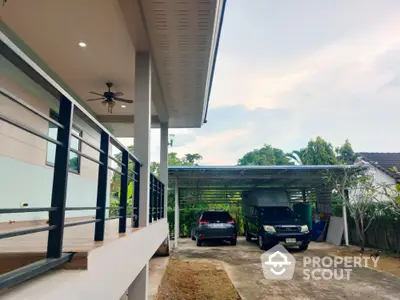 Spacious carport with modern home exterior and lush greenery