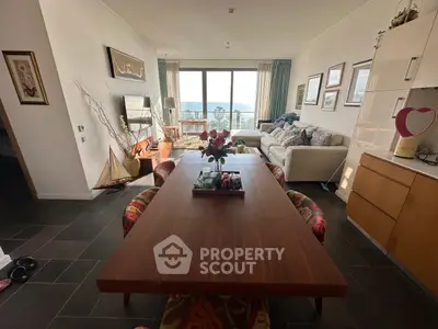 Spacious living room with ocean view, modern decor, and elegant dining area.