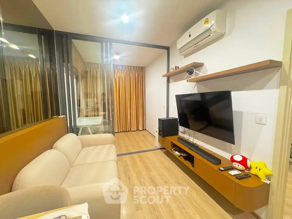 Modern living room with sleek design, featuring a wall-mounted TV, air conditioning, and stylish furniture.
