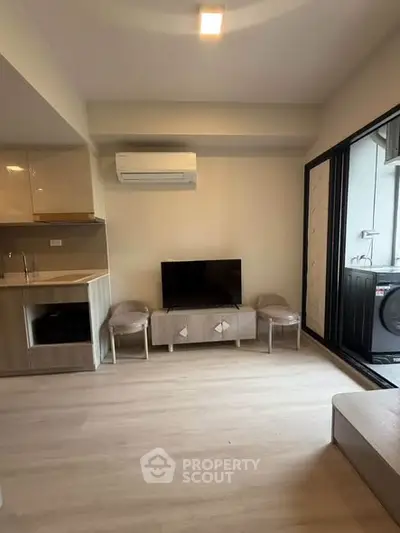 Modern living room with sleek furniture and balcony access in a stylish apartment.