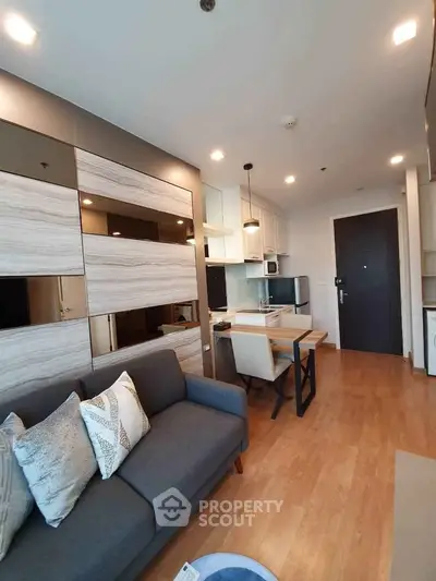 Modern living room with stylish decor and open kitchen layout in a cozy apartment.