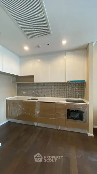 Modern kitchen with sleek cabinetry and built-in appliances in a stylish apartment.