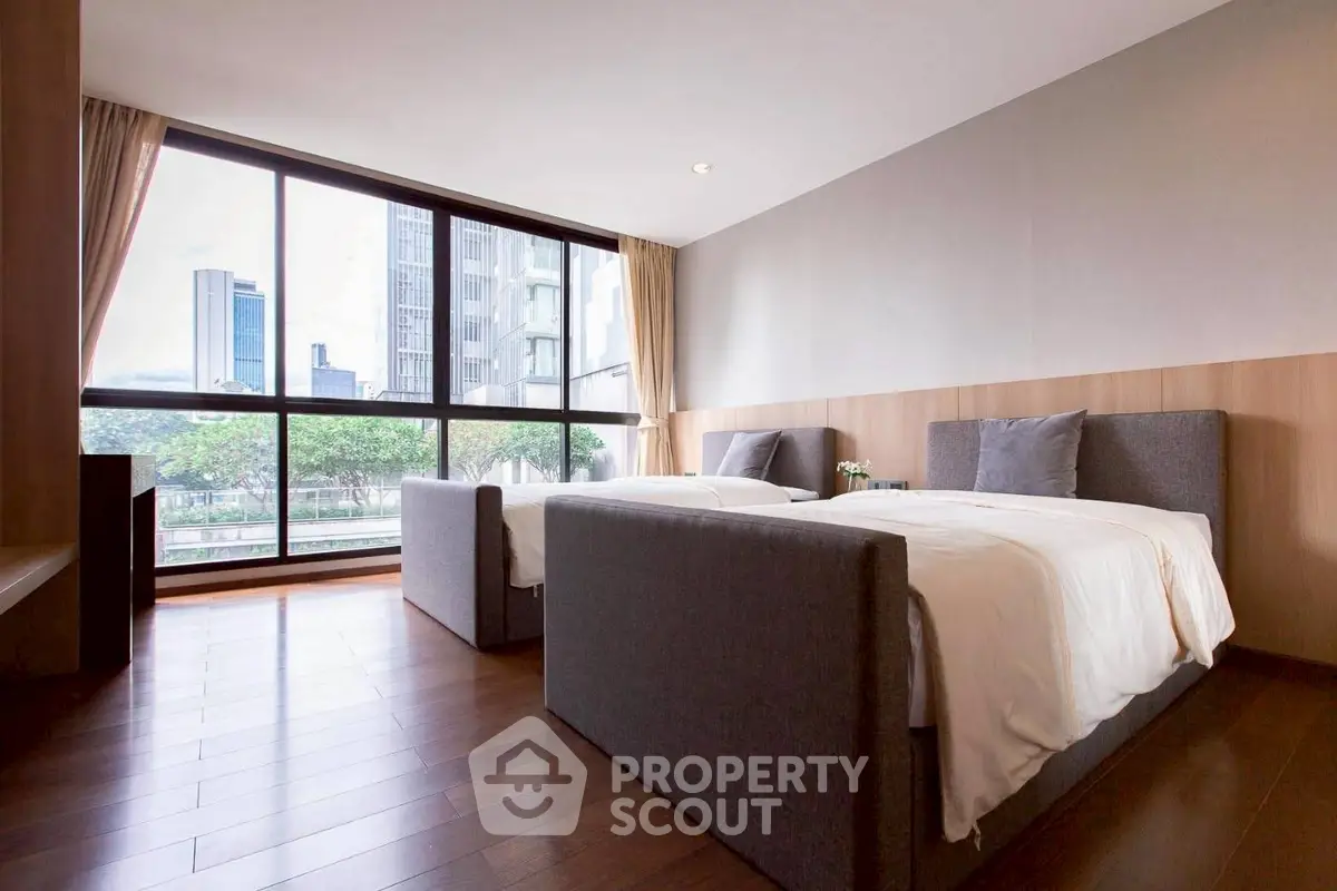 Spacious modern bedroom with large windows and city view