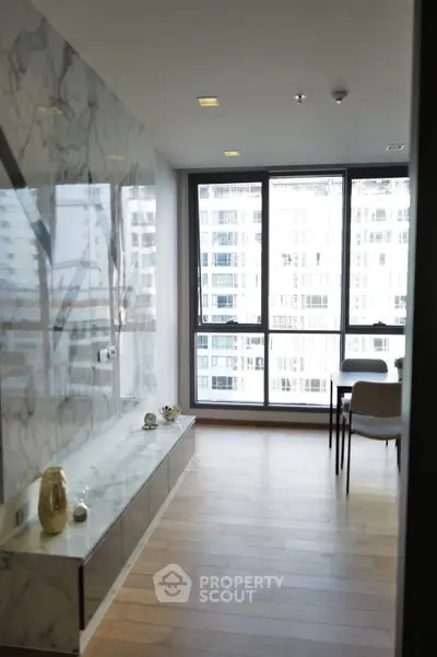 Modern living room with marble wall and large windows offering city view