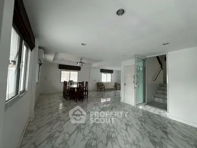 Spacious open-plan living area with marble flooring and elegant dining set