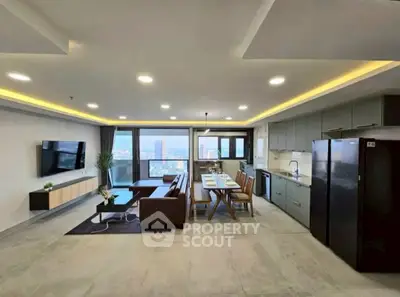 Spacious open-layout living room with modern kitchen and stunning city view.