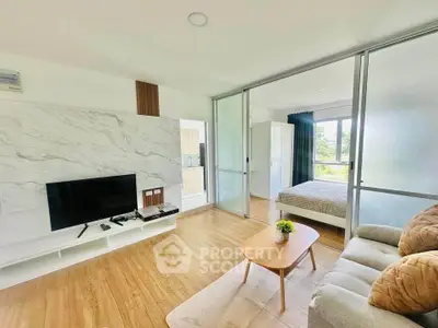 Modern open-plan living room with TV and cozy bedroom in bright apartment