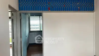 Spacious interior with tiled flooring and large window offering natural light, ideal for customization.