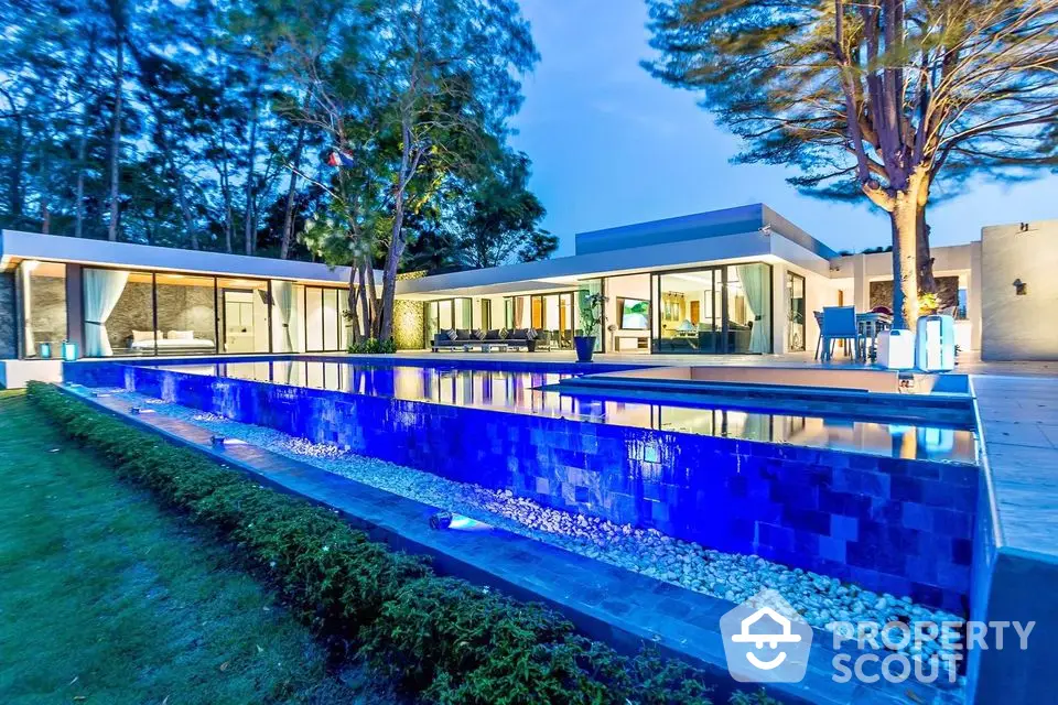 Luxurious modern villa with stunning illuminated pool and spacious outdoor area.