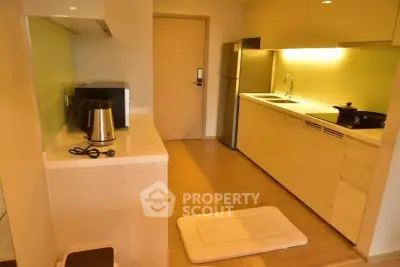 Modern kitchen with sleek cabinetry and stainless steel appliances in a cozy apartment.