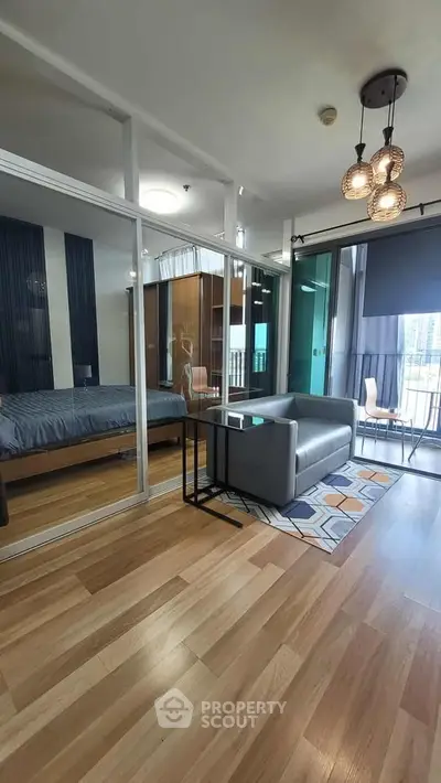 Modern apartment with open layout, featuring a cozy living area and stylish bedroom separated by glass walls.