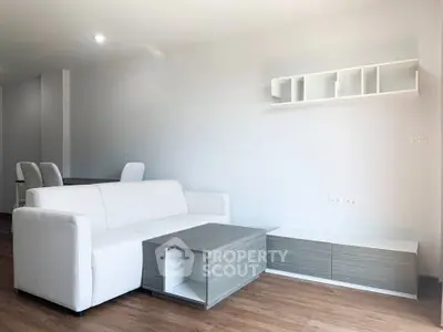 Modern living room with white sofa and sleek furniture in a minimalist design.