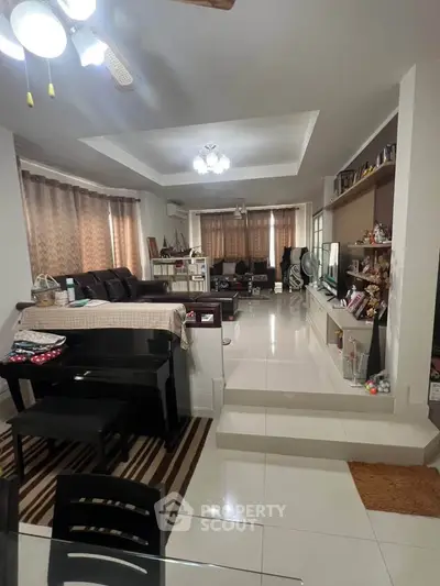 Spacious living room with elegant decor and modern furnishings, featuring a piano and entertainment center.