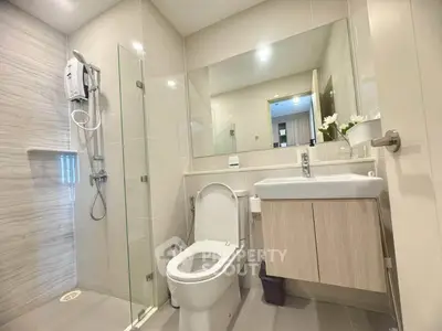 Modern bathroom with sleek fixtures and glass shower enclosure in a contemporary apartment.