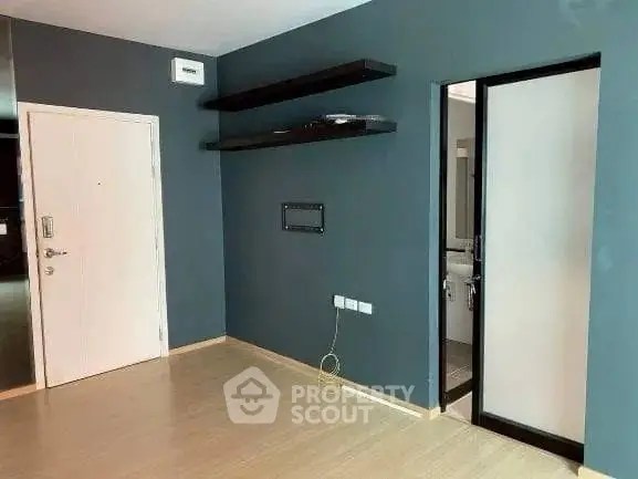 Modern interior with sleek shelves and minimalist design, featuring a door leading to a bathroom.
