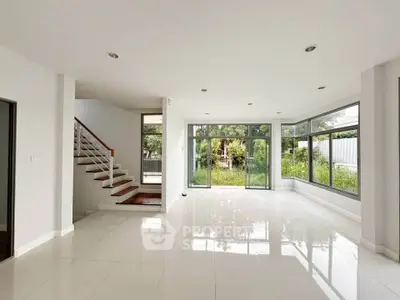 Spacious modern living room with large windows and garden view