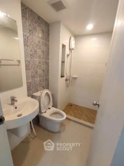 Modern bathroom with stylish tiles and walk-in shower in contemporary apartment.