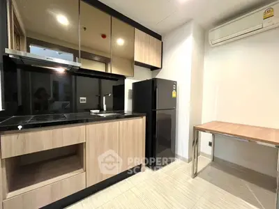 Modern kitchen with sleek cabinetry and black countertops in a contemporary apartment.