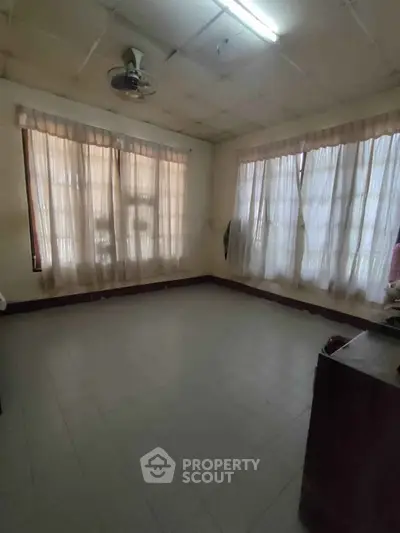 Spacious room with large windows and natural light, ideal for versatile use.