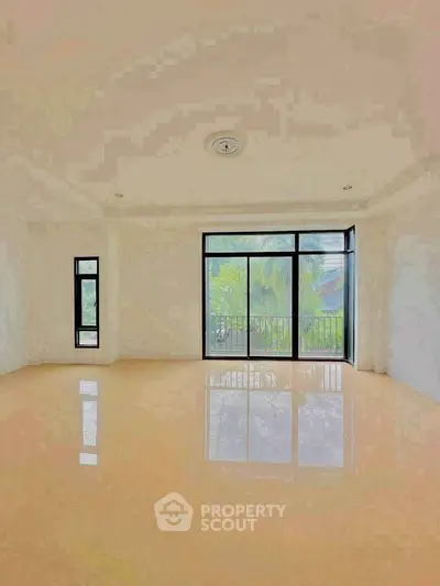 Spacious empty room with large windows and balcony view