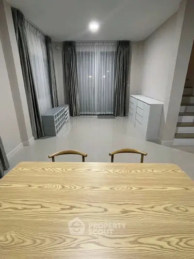 Modern minimalist interior with sleek wooden table and elegant curtains