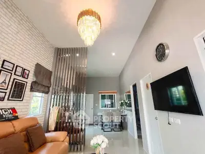 Modern living room with elegant chandelier and open layout, featuring stylish decor and comfortable seating.