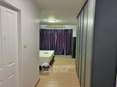 Spacious bedroom with modern design and ample closet space in a stylish apartment.